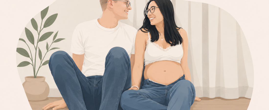 Le dernier mois avant l’arrivée de bébé - Journal de Papa Pregnant woman and partner sit on the floor at home, smiling at each other with a plant nearby.